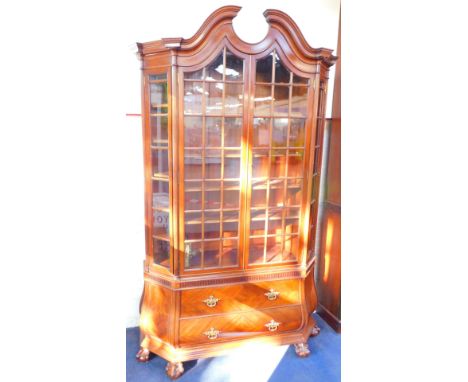 A Dutch 18thC style mahogany bombe display cabinet, the broken arch pediment over two glazed doors opening to reveal four she