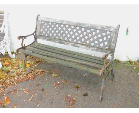 A garden bench, with cast iron supports and slatted seat and lattice back.