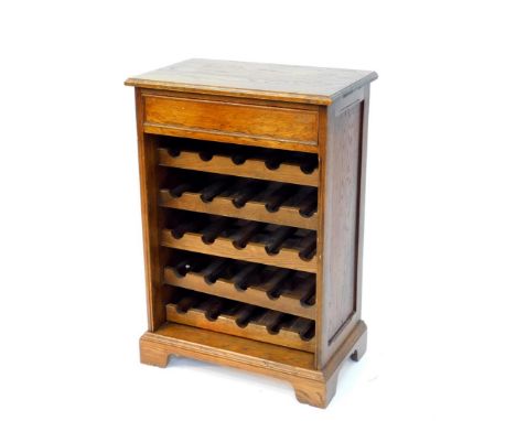 An oak wine rack, of chest form, with a single frieze drawer, above five bottle trays, raised on bracket feet, 88cm high, 60c