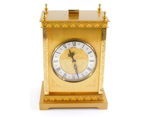 A Junghans brass cased carriage clock, the circular dial with silvered chapter ring bearing Roman numerals, quartz movement, 