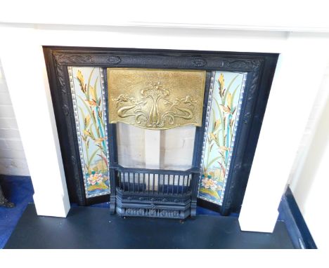 A Victorian Art Nouveau style cast iron fireplace, with a brass hood, and set with two five tile panels decorated with bull r