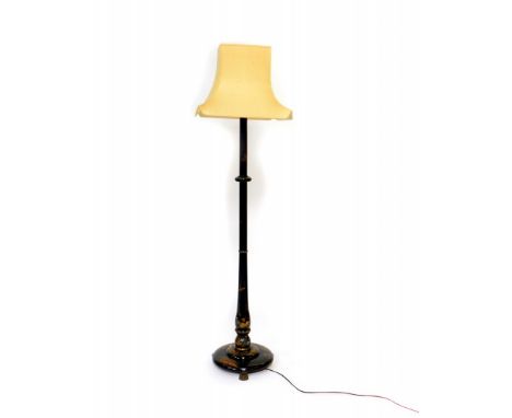 An Edwardian black Japanned lacquer standard lamp, raised on three brass lion paw feet, with shade, 185cm high. 