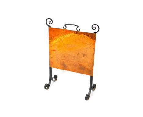 An Arts &amp; Crafts style cast iron and beaten copper firescreen, 75.5cm high, 56.5cm wide.