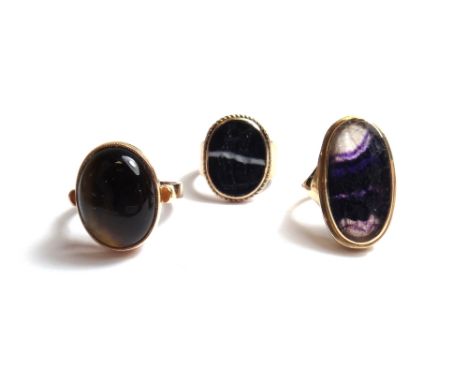 A gold ring mounted with an oval blue john, a gold ring mounted with an oval moulded intaglio, simulating agate and a gold ri