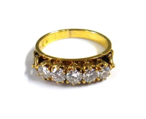 A gold and diamond set five stone ring, claw set with a row of circular cut diamonds, the mount decorated with pierced sides,