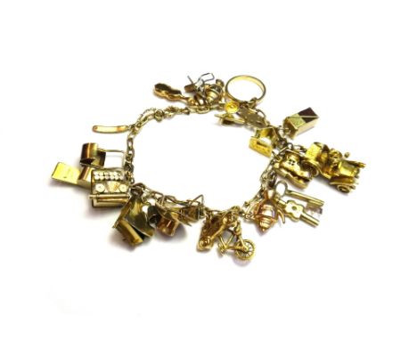 A gold oval link charm bracelet, fitted with a variety of mostly gold pendants and charms, including; a 9ct gold wedding ring