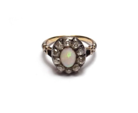 An opal and diamond set oval cluster ring, mounted with the oval opal at the centre, within a surround of ten cushion shaped 