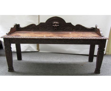 A Victorian carved oak hall bench with lions head mount, 122cm wide.