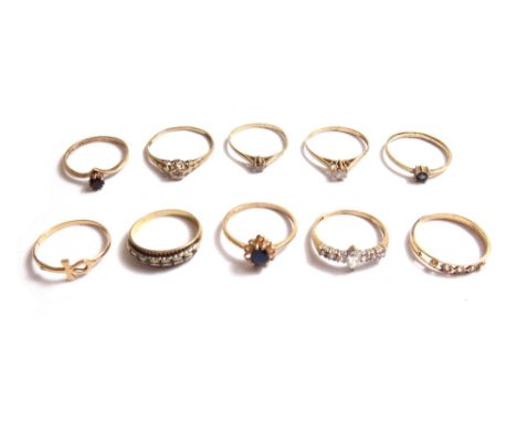 A 9ct gold ring, mounted with a pear shaped sapphire, a 9ct gold and colourless gem set ring and eight further gold and mostl