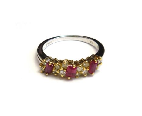 An 18ct white gold, ruby and diamond set ring, claw set with three rectangular cut rubies alternating with pairs of circular 