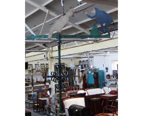 A wrought iron weather vane, early 20th century, polychrome painted with a monkey and cockatoo surmount over a traditional fo