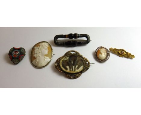 A Victorian gilt metal mounted shaped oval brooch, glazed with a feathered hair locket compartment, a gold, red and colourles