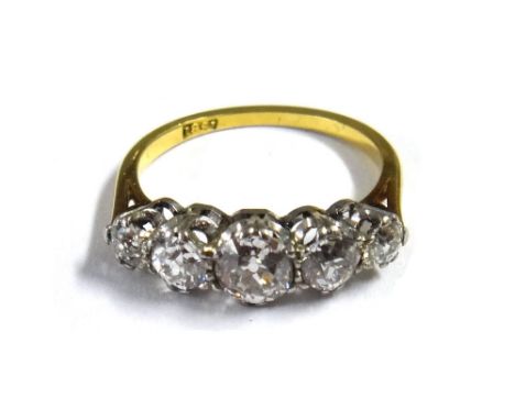 A gold and diamond set five stone ring, claw set with a row of cushion shaped diamonds, graduating in size to the centre ston