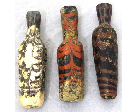 Three marvered glass flasks, Near Eastern, 8th-9th century, each of slightly tubular faceted shape slightly flaring upward, w