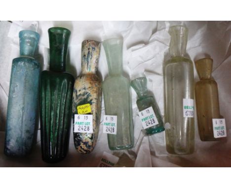 Seven intact glass flasks, mostly Iran 12th century, comprising a large green glass flask with ribbed body, a large light blu