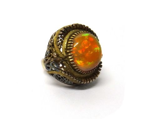 An opal set single stone dress ring, in an abstract design with pierced decoration between textured shoulders, detailed 14K, 