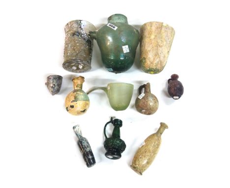 A group of Roman glass vessels, comprising three pouring vessels; two beakers; four flasks; a small green mould blown flask a