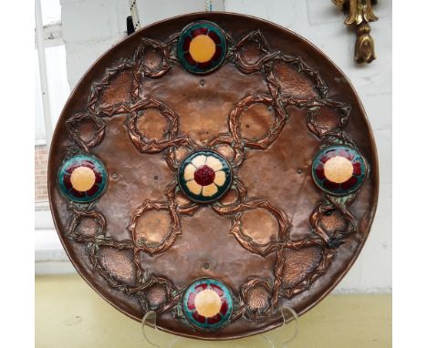 An Art Nouveau copper charger, early 20th century, the body embossed with a geometric foliate pattern and interspersed with f