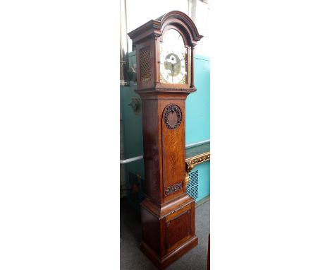 A 20th century oak eight day Westminster chime longcase clock with eight striking hammers (bells lacking), the arch top thirt