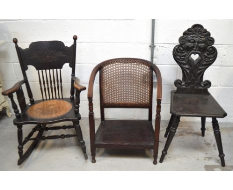 A heavily carved ebonised hall chair (af), a stick back rocking chair and a low chair with hand caned back (3).