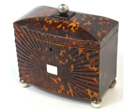 A Regency bow fronted pressed tortoiseshell tea caddy, the shaped hinged lid centred with a white metal roundel enclosing two