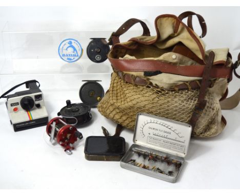 A vintage fishing bag containing a quantity of fishing accessories to include cased dry flies, trout wet flies, and reels to 