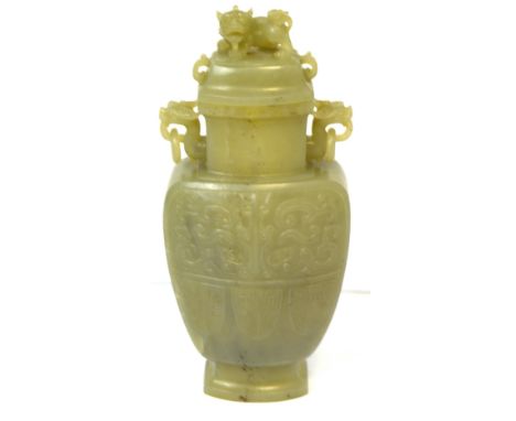 A Chinese carved jade vase and cover, the cover set with a chi chi finial above twin mask ring loop handles and lozenge carve