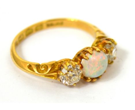 An 18ct yellow gold opal and diamond ring the central opal flanked either side by a diamond, each diamond approx 1/4ct, size 