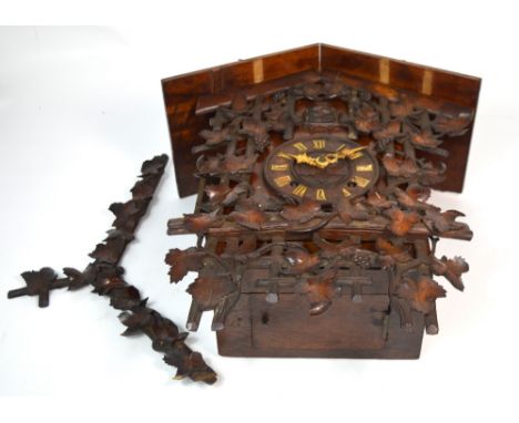 A Black Forrest style carved eight day cuckoo clock, the dial set with Roman numerals, height approx 50cm (af). CONDITION REP