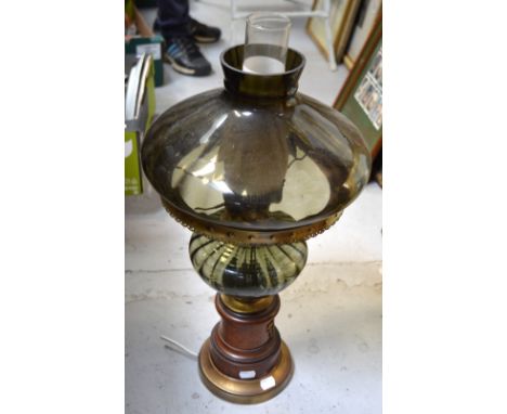 An oil lamp with grey glass shade on a wooden base with armorial decoration, converted for electricity, height 62cm.