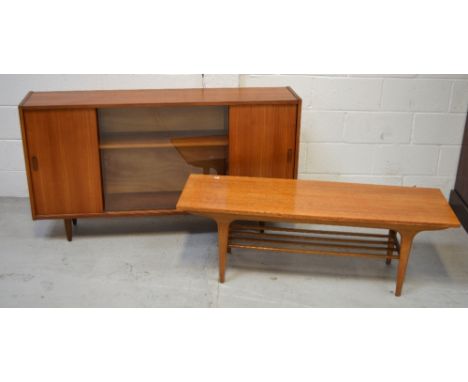 A retro c1960s rectangular coffee table with lower slat shelf on tapering legs, length 122cm and a bookcase with a central gl