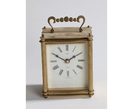 Junghans brass cased carriage clock, the white dial with Roman numerals and retailers name Smiths, quartz movement
