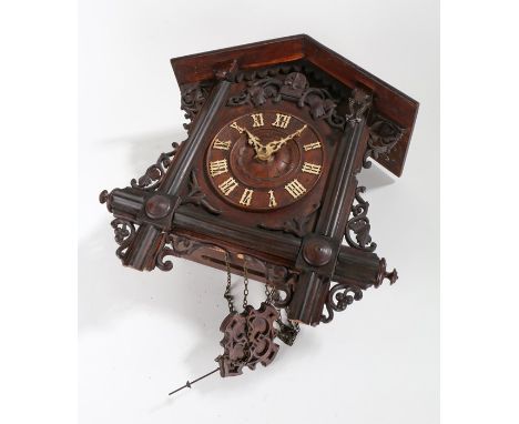 Black forest style Cuckoo clock, with arched pediment and white Roman numerals surrounded by a pierced leaf carved frieze, wi