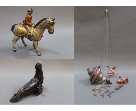 A small collection of tinplate clockwork toys to include a German DRPA jockey & horse, a seal, a monkey on a stick, a rattle 