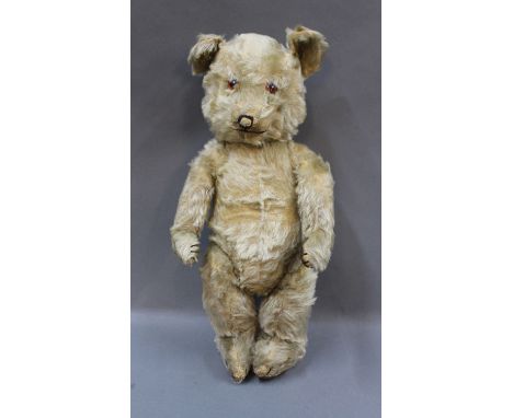 A Chiltern Hug Mee musical teddy bear, having glass eyes, stitched nose and mouth, drum stick legs and with pressure- operati