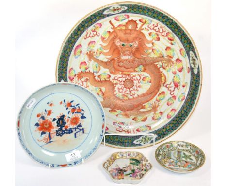 A Chinese Imari saucer dish; a teapot stand; a famille verte saucer; and a dragon charger 