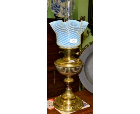 A brass oil lamp with vaseline shade 
