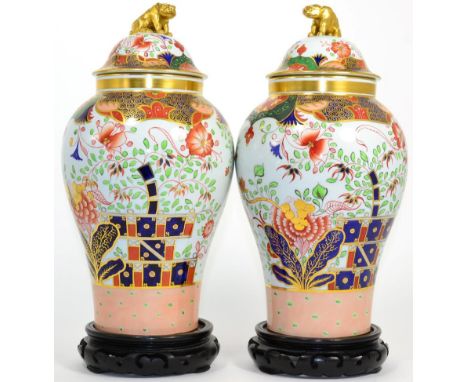 A pair Spode of Imari pattern jars and covers, raised upon ebonised wooden bases