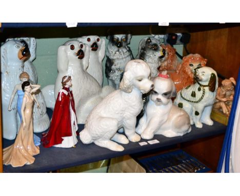 A shelf of decorative ceramics including three pairs of dogs, a pair of lions, two Nao dogs, Royal Worcester figure 'In Celeb