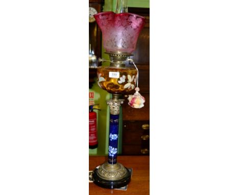 A Corinthian blue ceramic column oil lamp with an amber coloured floral decorated reservoir 