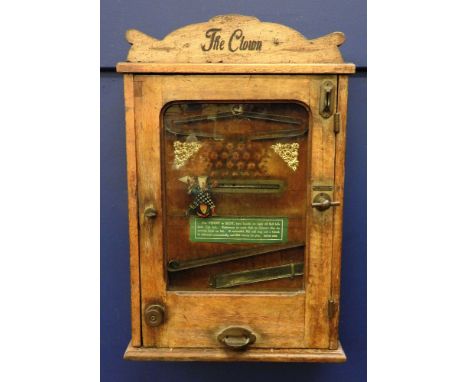 'The Clown' an early 20th century penny in the slot arcade machine, in an oak case with branded mark P.M.W.G. XX, together wi