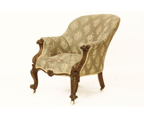A Victorian carved mahogany parlour chair, with ceramic castors