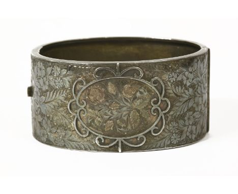 A Victorian silver hinge bangle with floral scrolling decoration on top section, Birmingham 1882