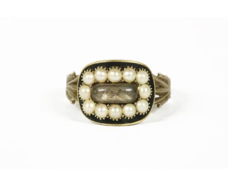 A Georgian gold memorial ring, central glazed compartment containing plaited hair with a border of split pearls to black enam