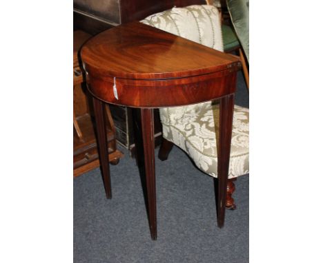 An early 19th century mahogany folding card table opening to an oval blue baize top, on four tapered legs, opens to 80cm