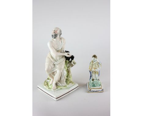 A 19th century Staffordshire pottery religious figure of Elijah and the crow, 24cm high, together with a smaller pearl ware f