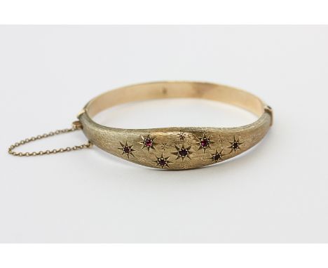 A 9ct gold and gem set hinged bangle