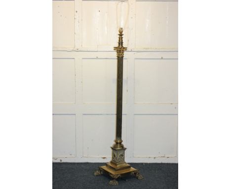 A brass column standard lamp on square step base with paw feet, 132cm high