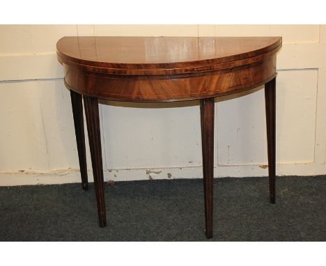 A George III cross handed mahogany card table with folding semi-circular top enclosing green baize, on square tapered legs, 9