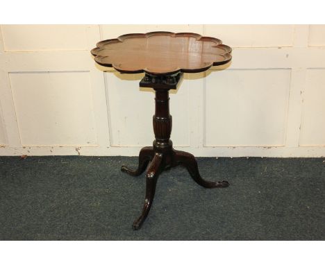 A George III tripod table with circular moulded 'piecrust' top, on birdcage support, carved baluster stem and tripod base wit